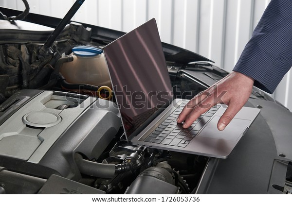 Car mechanic\
using computer in auto repair\
shop