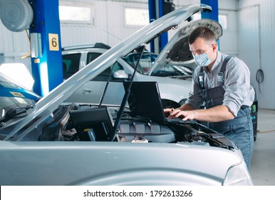 Car Mechanic Using A Computer Laptop To Diagnosing And Checking Up On Car Engines Parts For Fixing And Repair