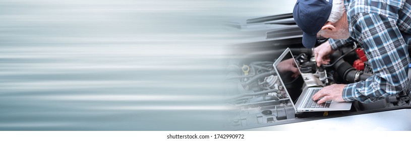 Car mechanic using laptop for checking car engine; panoramic banner - Shutterstock ID 1742990972