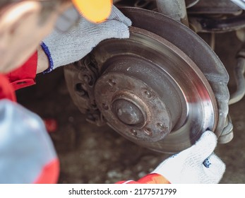 Car Mechanic Wearing Uniform Examining Brake Pads With Caliper. Car Safety System