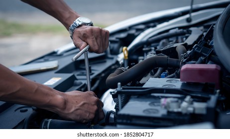 A car mechanic working in a car repair professional mechanic car maintenance service hand holding a wrench - Shutterstock ID 1852804717