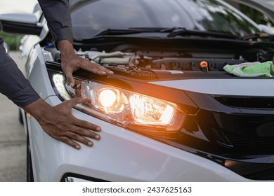 Car mechanic's hands holding car headlights, auto parts concept Car mechanic changes damaged car bulbs and inserts new bulbs under engine maintenance concept. - Powered by Shutterstock