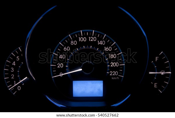 car
meter with white and blue light at dark
background