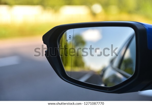 Car mirror with\
blind spot warning. The car with blind spot monitor which detects\
other vehicles on the side.