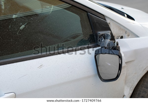 Car mirror broken off,\
consequences of a car accident. Damage to a car sedan, vandalism,\
hooliganism, car damage. Torn right side view mirror of the\
transport