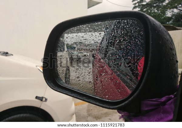 Car mirror, raining\
outside