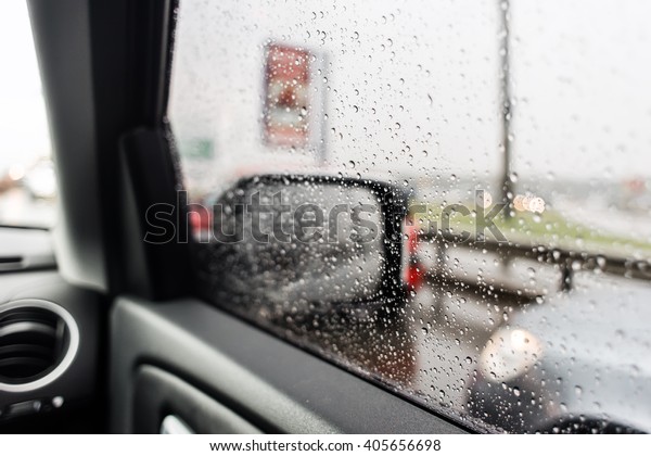 Car mirror, raining\
outside