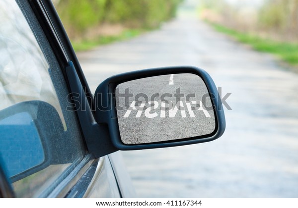 Car mirror. The reflection in the mirror of the\
word finish. Business\
concept