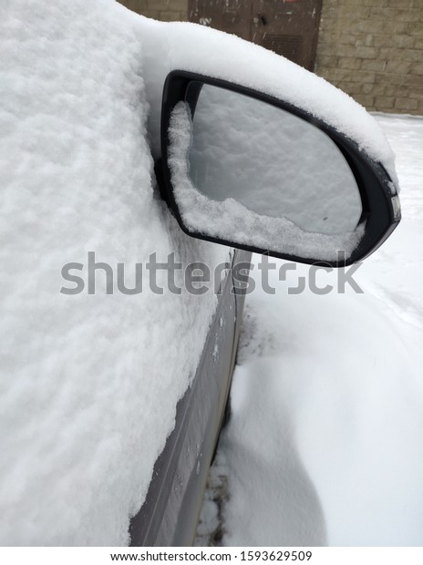 Car mirror in the snow close-up. Side\
mirror of vehicle. Car standing in snow. Snowdrift snow by vehicle.\
Snow covered car. Winter, car in\
snowdrift.