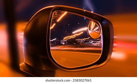 Car mirror and window reflection while driving at night. Long exposure from the car on highway. Driving at night city with bright lights and traffic. Fast moving.