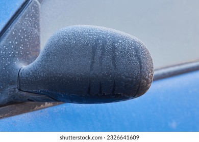 car mirror in winter,the car's side mirror is covered in frost