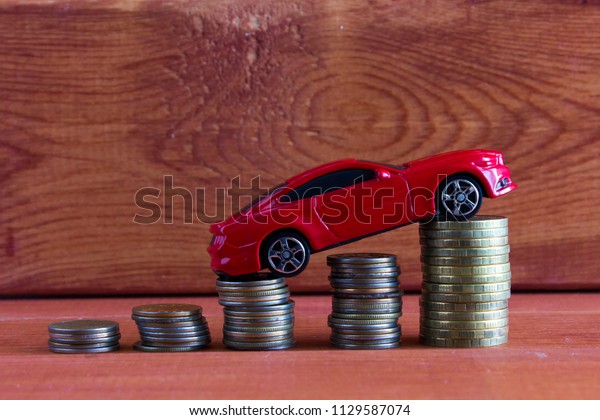 Car model and coins. Concept of auto loan, auto\
insurance, leasing.
