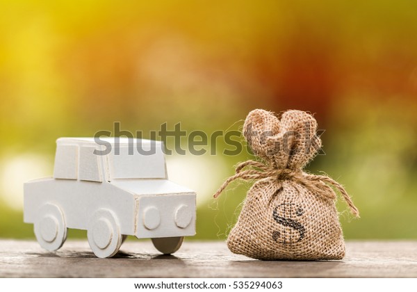 A car model\
and money bag for loans\
concept.