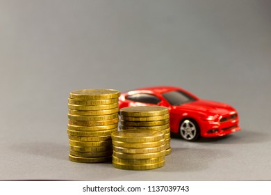 Car Model On  Background Of Coins. Concept Of Leasing, Auto Loan, Auto Insurance, Taxes.