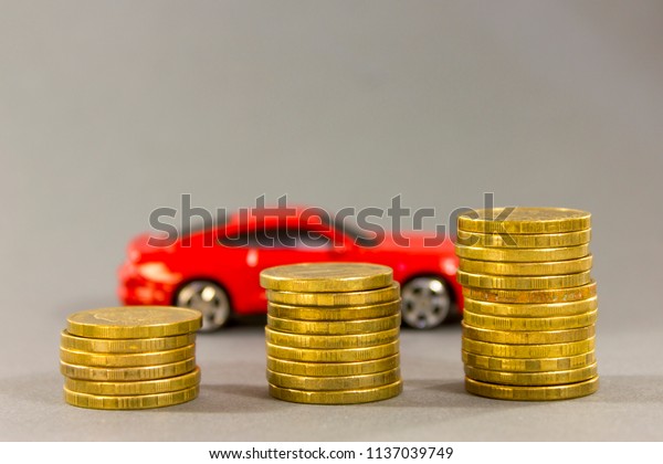 Car model on  background of coins.\
Concept of leasing, auto loan, auto insurance,\
taxes.