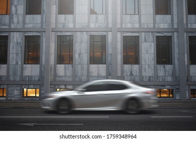 car in motion blur by street of business district