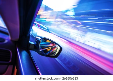 Car in Motion at Night. Colorful Motion Blurs. Transportation Concept Photo.