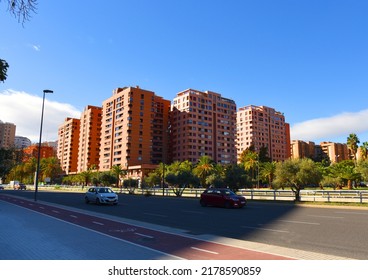 Car in motion on road in city Valencia. City street, road traffic, cars on road. Urban buil architecture. Multi-storey residential buildings with palm trees in city center. Bike path at traffic road. 