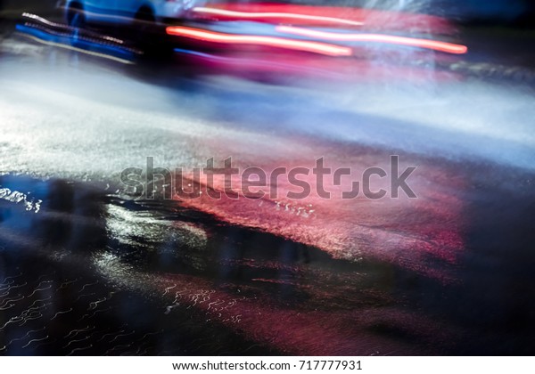 car in motion splashing rain water driving at night\
blurred view