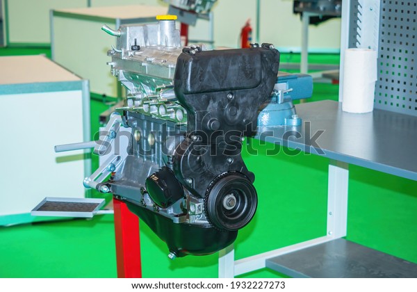 Car motor closeup. Engine is fixed to rack. Car\
engine repair. concept - inspection of a car engine for breakdowns.\
Replacement of small parts in auto motor. Elimination of breakdowns\
in motor.
