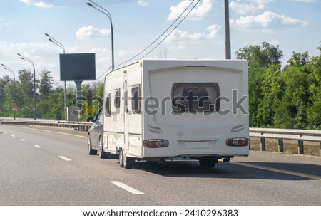 Car with motor home trailer on freeway road