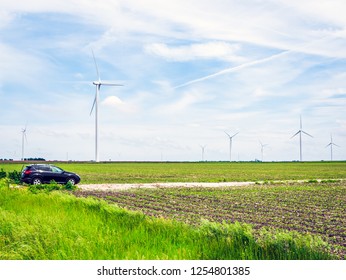 Car Motor Vehicle Is Parked Near Wind Turbine Power Farm In US Rural Community Midwest Corn Field Future