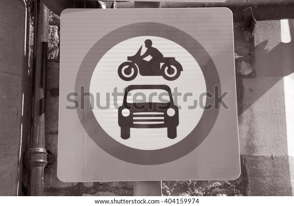 Car and Motorbike Traffic Sign in Urban\
Setting  in Black and White Sepia Tone\
