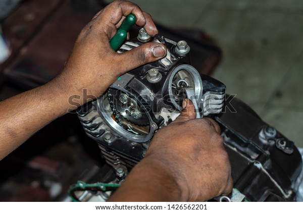 car motorcycle engine maintenance works at workshop
with hand tools