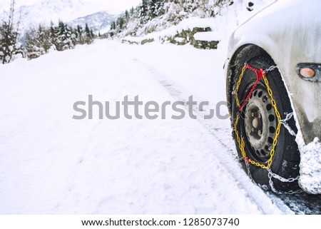 Car with mounted snow chains in wintry environment
