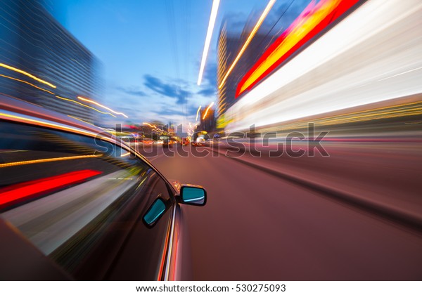 The car moves at fast speed at the\
night. Blured road with lights with car on high\
speed.