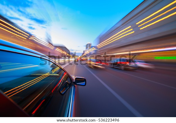The car moves at fast speed at the\
night. Blured road with lights with car on high\
speed.