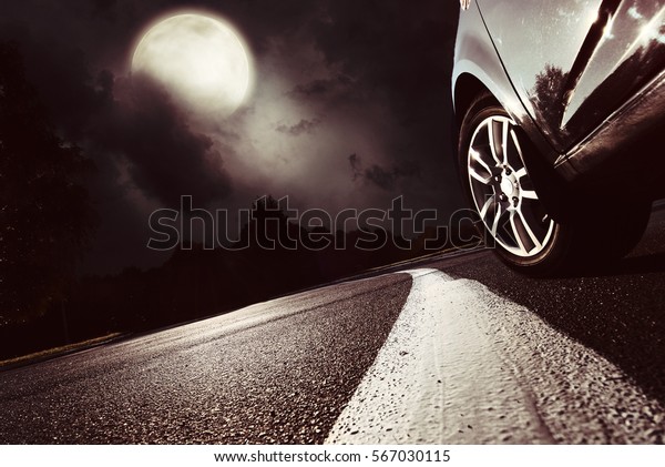 The car moves at fast speed at the\
night. Blured road with lights with car on high\
speed