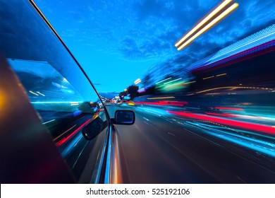 The Car Moves At Great Speed At The Night. Blured Road With Lights With Car On High Speed.