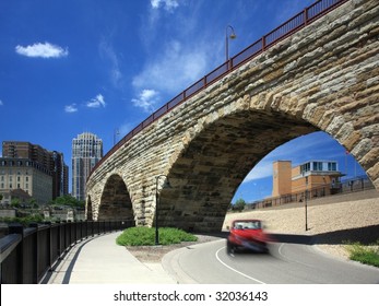 Car moving in downtown Minneapolis and  Stone Arch bridge