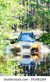 A car moving through a large puddle in the woods