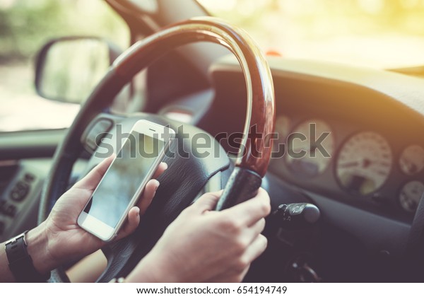Car\
navigator. Woman holding the phone while\
driving