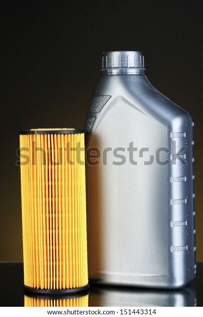Car\
oil filter and motor oil can on dark color\
background