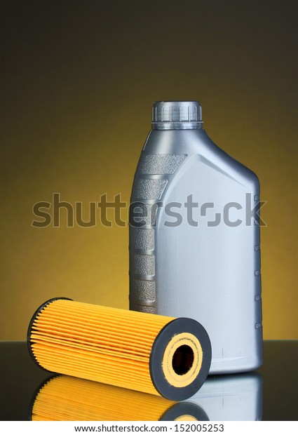 Car\
oil filter and motor oil can on dark color\
background