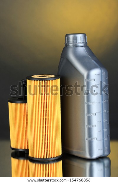 Car oil filters and motor oil can on dark\
color background
