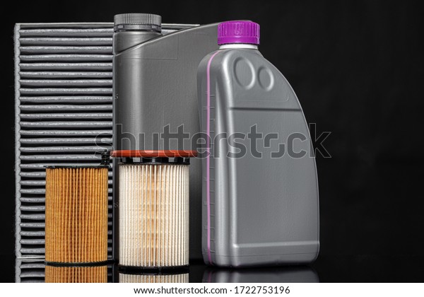 Car oil filters and motor oil can on dark background,\
close up.