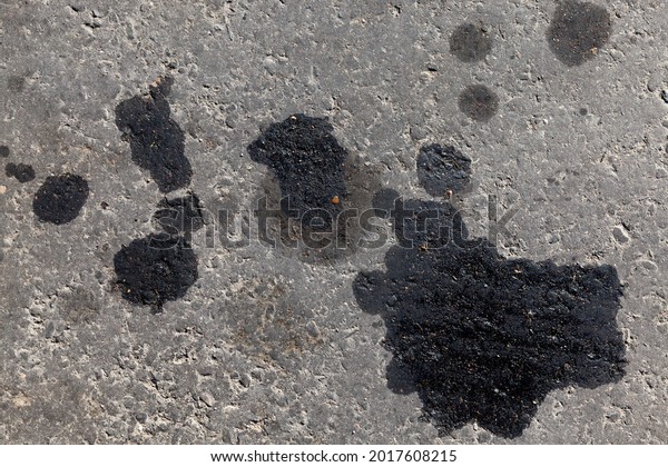 car oil stains leaked out of\
the car onto the asphalt road, close-up of car oil stains on the\
road