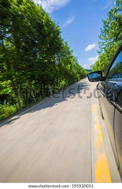 car on country road under\
blue sky