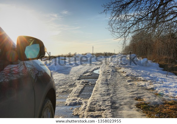 The\
car on a country spring road with the remains of\
snow