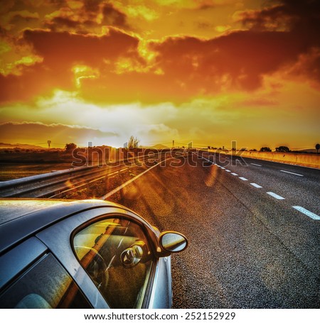 car on the edge of the road under a scenic sky at sunset. Processed for hdr tone mapping effect.