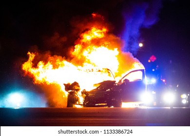 Car On Fire At Night With Police Lights In Background No One