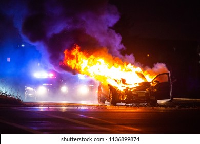 Car On Fire At Night With Police Lights In Background No One