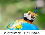 A car on globe on green background. Miniature car toy on globe. Travel concept