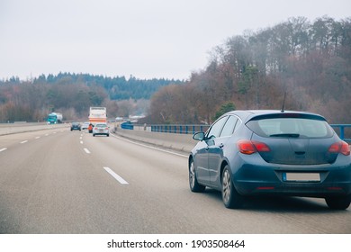 Car On A Highway That Goes Through Forest. Autobahn In Germany 