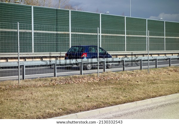 The car on the road fenced with a net against animals\
running in