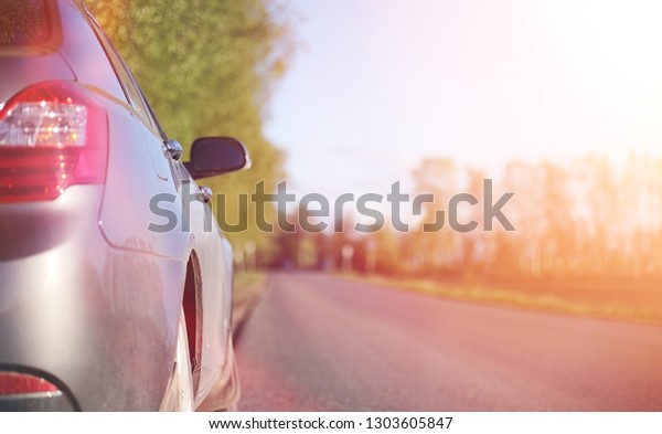 The car is on the road. Summer road\
on which there is a parked car. Travelling by\
car\
